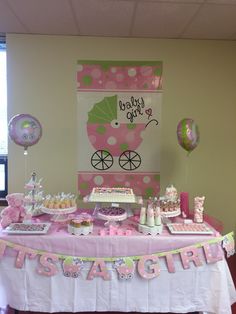 a pink and green baby shower table with balloons, cake, cupcakes and decorations