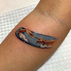 a tattoo on the arm of a person with a painting style image of two hands coming out of a surfboard