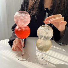 a woman sitting at a table with two wine glasses