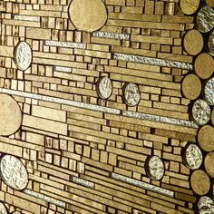 a wall made out of gold and silver coins with circles on it's sides