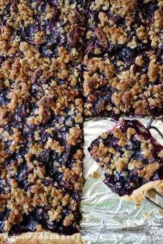 a pie with blueberries and crumbled toppings on top is cut into pieces