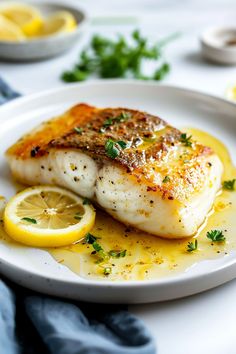 a white plate topped with fish and lemon slices