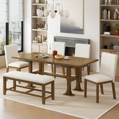 a dining room table with white chairs around it