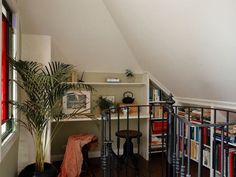 a room with bookshelves and a plant in the corner next to a window