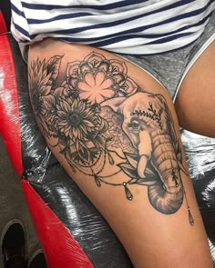 an elephant and flowers tattoo on the thigh