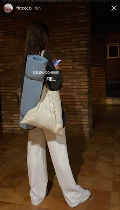 a woman in white pants holding a bag and cell phone with the text, ella domino free on it