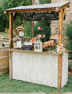 an outdoor dessert stand with donuts and pies on it