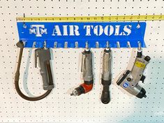 tools are hanging on the wall with measuring tape over them and below it is a ruler that says tm air tools