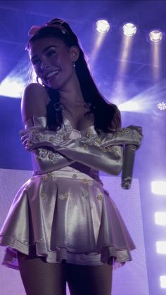 a woman in a silver dress on stage