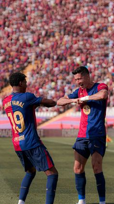 two men are playing soccer in front of an audience