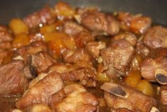 meat and potatoes are being cooked in a wok with some brown sauce on top