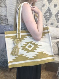 a woman is holding a large bag with tassels