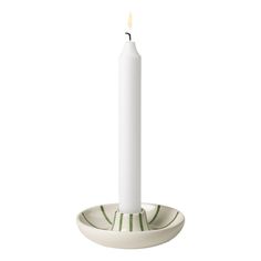 a white candle sitting on top of a saucer with a green stripe around it