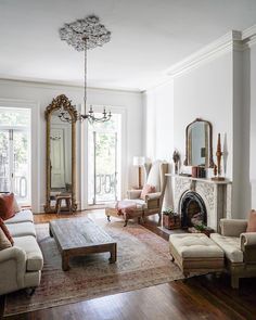 a living room filled with furniture and a fire place in the middle of a wooden floor