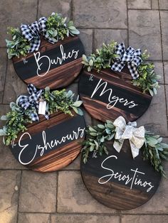 three wooden signs with greenery and bows on them