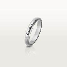 a white gold wedding ring with the word love written on it and two diamonds in the middle