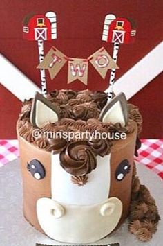 a birthday cake decorated with chocolate frosting and icing on a table in front of a barn door