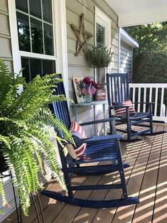 two blue rocking chairs sitting on a porch