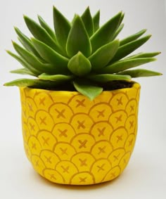 a yellow potted plant sitting on top of a white table