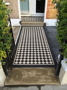 a black and white checkerboard floor in front of a door with steps leading up to it