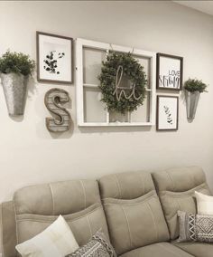 a living room filled with furniture and pictures hanging on the wall above it's windows