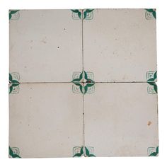 four square tiles with green and white designs on them