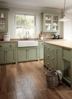 a kitchen with green cabinets and wooden floors