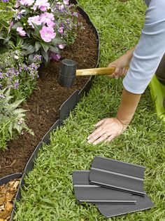 a person is digging in the grass with a shovel and some gardening implements next to them