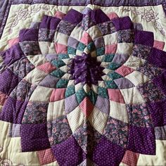 a purple and white quilt with an intricate design