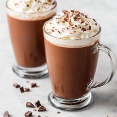 two glasses filled with hot chocolate and whipped cream