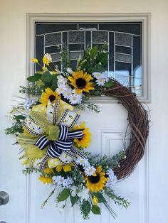 a wreath with sunflowers and daisies on the front door