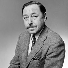 black and white photograph of a man in a suit with a moustache on his face