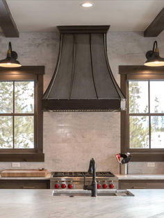 a kitchen with an oven, range hood and windows