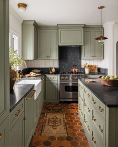 a large kitchen with green cabinets and black counter tops, along with an area rug on the floor