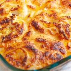 a casserole dish with cheese and meat in it on a tableclothed cloth