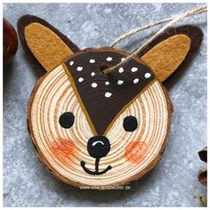 a wooden ornament with a deer's head painted on it