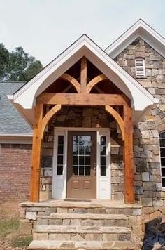 the front entrance to a home with stone pillars and arches on it's sides