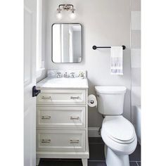 a white toilet sitting next to a sink in a bathroom under a vanity with a mirror above it