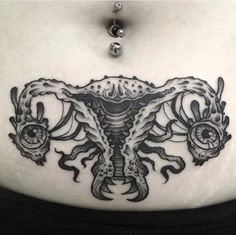 a woman's stomach with an intricate tattoo design on the belly and chest area