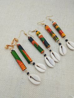 The handmade cowrie African Kente earrings are approximately 3.75 inches long. The earrings will come with back stoppers. They are available in pierced and non pierced options. The earrings come with back stoppers. These can vary in length due to sizes of natural shells. If you have any questions please feel free to contact us at anytime.                  Tips and Suggestions for Clip On (Non Pierced) Earrings to fit your ears comfortably: Clip on feels loose: Go slow and adjust carefully 1.Use your fingers or a small pair of pliers to gently open the fold, bringing the pad closer to the back of the earring. 2.Use pliers and slowly, gently tighten up the U shape at bottom 3.Try clip on pads Clip on feels tight: Test frequently as your adjusting them 1. Use your pliers to bring the pad slig Bohemian Adjustable Cowrie Shell Earrings, Handmade Bohemian Cowrie Shell Earrings, Bohemian Cowrie Shell Earrings, Diy Yarn Earrings, African American Jewelry, Afro Earrings, Cowrie Shell Earrings, African Inspired Jewelry, Afrocentric Earrings