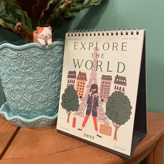 a book sitting on top of a wooden table next to a potted plant