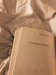 an open book sitting on top of a bed