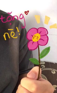 a person holding a flower in their hand with the words happy birthday written on it