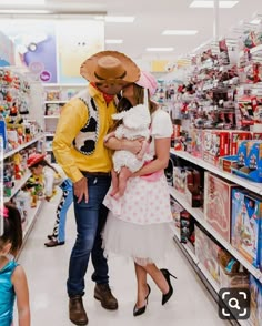 a man and woman are standing in the aisle of a toy store with their children