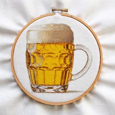 a cross stitch pattern with a mug of beer in it on top of a white sheet