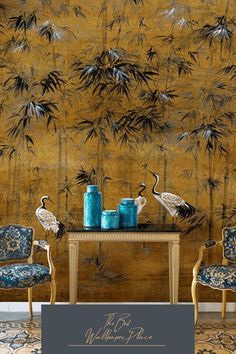 two chairs and a table with blue vases on it in front of a bamboo wall