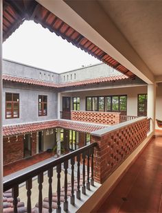 an open balcony with wooden railings and red tile on the walls, leading to several rooms