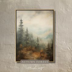 an autumn forest scene with fog and trees in the foreground, framed on a white wall