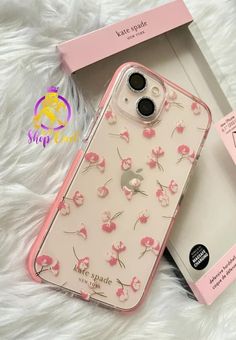 an iphone case with pink flowers on it next to a box and white furnish