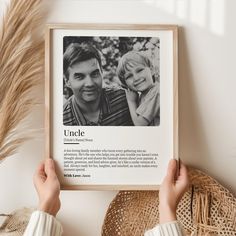 a person holding up a framed photo with the words uncle and an image of two people